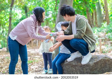 Mother Using Insect Repellent In The Forest