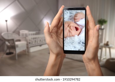 Mother Using Modern Mobile Phone As Baby Monitor At Home