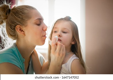 Madre usando "aspiración aspiradora nasal mucus moco aspiradora inhalación" para sacar el nido de la nariz. Little Girl ha estado chupando no de los síntomas de la nariz por parte de su madre.