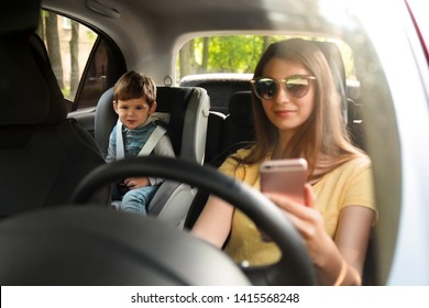 Mother Using Phone While Driving Car With Her Son On Backseat. Child In Danger