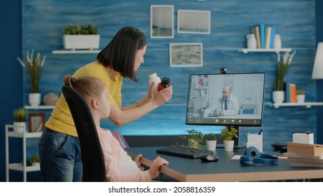 Mother Using Video Call With Doctor For Healthcare Treatment And Advice. Parent Holding Bottle Of Pills Asking Medic On Telemedicine About Medication For Telehealth And Sick Child