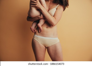 Mother With Visible Postpartum Body Marks With Baby. C Section Caesarean Operation Heal Mark On Mother Belly. Postpartum Recovery.