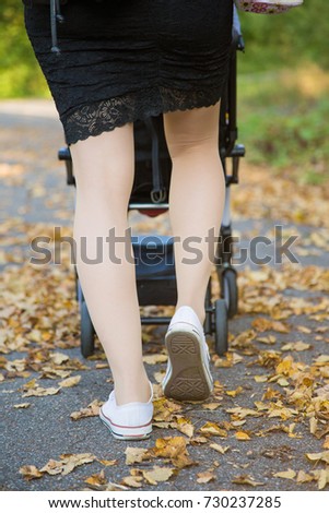 mother walking in the park with her baby in stroller