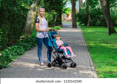 Mother walking while pushing a stroller in the park