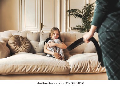 Mother wants to punish her child with belt in her hand. An angry mom punishes her daughter for her offense and hits baby with belt. Concept of family quarrels problems and parenting
