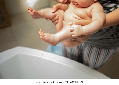 Mother Washes Her Baby After Stool At The Shower