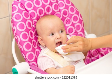 Mother Wipes Baby's Mouth With Napkin