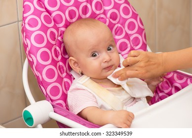 Mother Wipes Baby's Mouth With Napkin