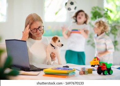 Mother Working From Home With Kids. Homeschooling And Home Office.  Quarantine, Closed School, Coronavirus Outbreak. Self Isolation And Social Distancing. Children Make Noise And Disturb Mom At Work. 