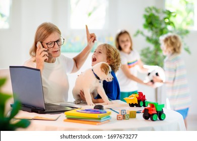 Mother working from home with kids. Homeschooling and home office.  Quarantine, closed school, coronavirus outbreak. Self isolation and social distancing. Children make noise and disturb mom at work. 