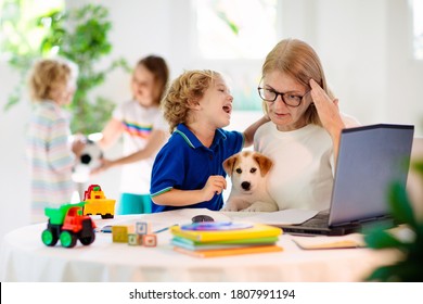 Mother Working From Home With Kids. Homeschooling And Home Office.  Quarantine, Closed School, Coronavirus Outbreak. Self Isolation And Social Distancing. Children Make Noise And Disturb Mom At Work. 