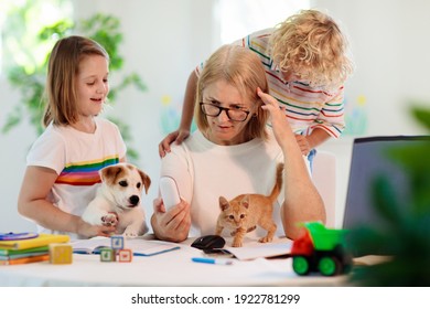 Mother Working From Home With Kids. Homeschooling And Home Office.  Quarantine, Closed School, Coronavirus Outbreak. Self Isolation And Social Distancing. Children Make Noise And Disturb Mom At Work. 