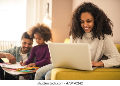 Mother Working From Home While Dad And Daughter Having Fun.