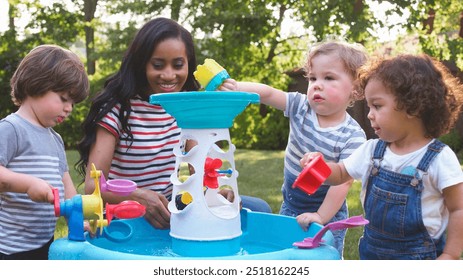 Mother And Young Children Playing With Water Table In Garden - Powered by Shutterstock