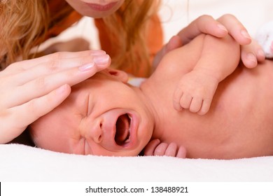 mothercare, young mother calms her newborn baby during she is crying and screaming