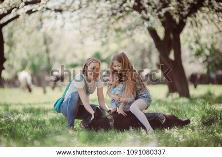 The mother,children and dog sitting on the grass