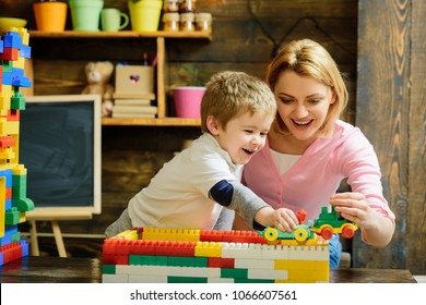 Motherhood Concept. Blond Mom And Son Play With Plastic Building Blocks Train. Excited Preschooler Playing With His Smiling Mother Or Kindergarten Teacher.