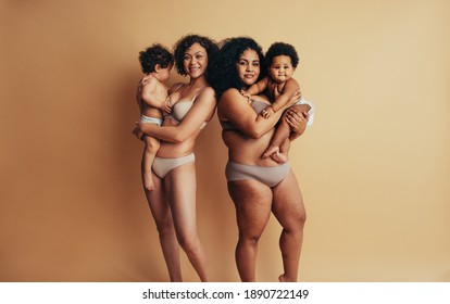 Mothers And Babies Standing Together On Mothers Day. Women With Postpartum Bodies Holding Up Their Babies In Their Arms.