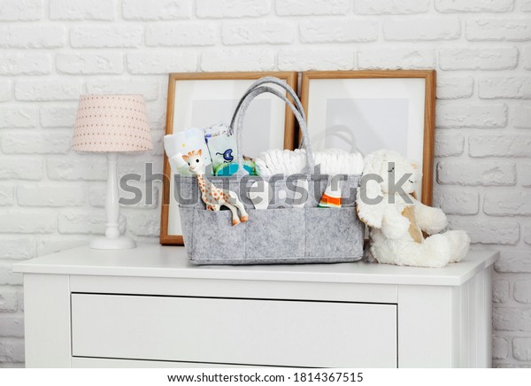 Mothers bag with toy, diapers and accessories\
on white background