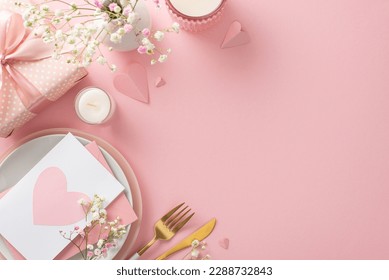 Mother's day brunch setting concept. Top view flat lay of plates, cutlery, tulips, gift box, vase, postal card, decorative hearts on pastel pink background with a space for promotional content or text