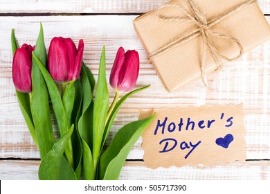 Mother's Day card and a bouquet of beautiful tulips on wooden background