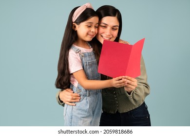 Mother's Day Card. Happy Beautiful Mom And Daughter Reading A Greeting Birthday Card Together