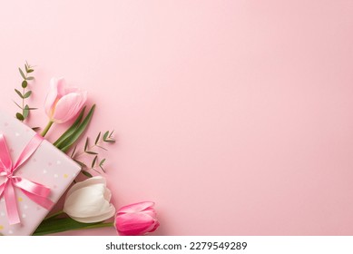 Mother's Day concept. Top view photo of stylish pink giftbox with ribbon bow and bouquet of tulips on isolated pastel pink background with copyspace - Shutterstock ID 2279549289