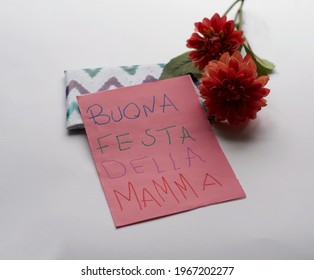 Mother's Day gifts. Flowers, a present and handmade greeting card with message in Italian “Buona festa della mamma”. Isolated in white background. Maternity, Love, Motherhood