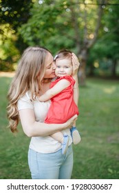 Mothers Day Holiday. Young Smiling Caucasian Mother And Girl Toddler Daughter Hugging In Park. Mom Embracing Child Baby On Summer Day Outdoor. Happy Authentic Family Childhood Lifestyle. 