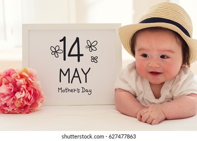 Mother's Day massage with happy baby boy with a pink flower - Powered by Shutterstock