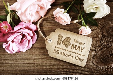 Mothers Day message with small pink roses on wooden table - Powered by Shutterstock