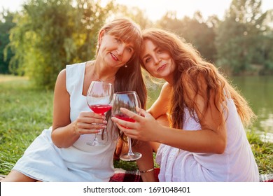 Mother's Day. Mother Drinking Wine With Her Adult Daughter In Spring Park. Family Having Picnic Outdoors. Women Spending Time Together