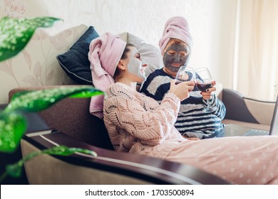 Mother's day. Mother and her adult daughter applied facial masks at home. Women chilling while having wine. Isolation during coronavirus quarantine