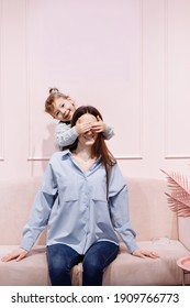 Mother's Day. Portrait Of Little Preschool Girl Kid Excited Young Mother Have Fun Playing Together At Studio, Happy Mom And Daughter Hug Cuddle Show Love, Enjoy Family Relaxing Weekend On Pink Sofa