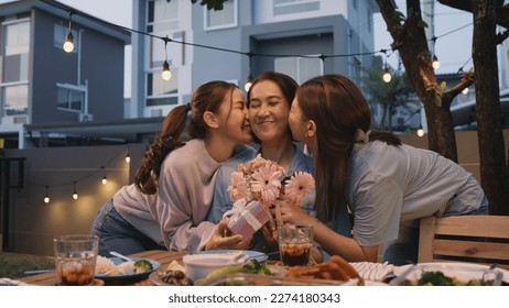 Mother's day two young child cuddle hug give flower gift box to mature mum. Love kiss mom asia people middle aged adult at home cozy dining table night dinner party happy smile enjoy relax warm time. - Shutterstock ID 2274180343