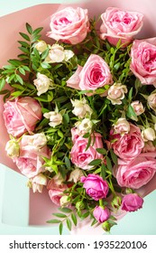 Mother's day, womens day or birthday greetings concept. Beautiful bouquet of blooming delicate pink roses and spring greenery on a green background. 