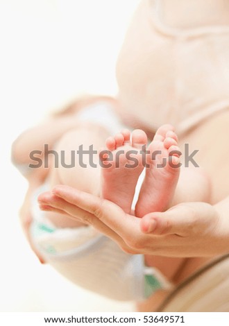 Mothers hand and the Baby`s Feet - indoors shoot