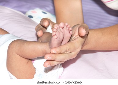 Mother's hand holding baby's legs with care. - Shutterstock ID 146772566