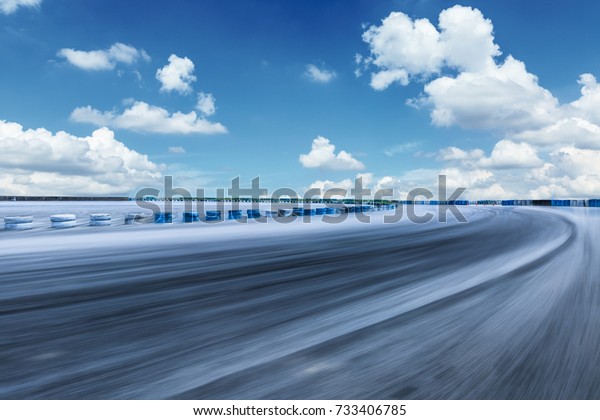 Motion blur\
asphalt road circuit and sky\
clouds