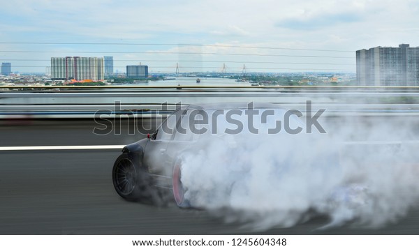 Motion blur Car driving drift with smoke on highway road\
in city. 