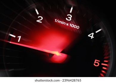 Motion blur of a car instrument panel dashboard odometer with red illuminated display.Car speedometer. High speed car speedometer and motion blur at night.