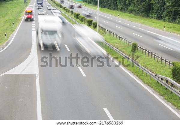 Motion blur of caravan and cars \
passing on a highway in summer. Car travels on the\
highway