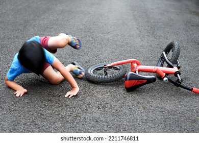motion blur a child falls off a red bicycle - Shutterstock ID 2211746811
