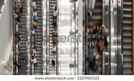 Motion blur of crowd Asian people transport on escalator at subway underground station in Hong Kong. Public transportation, Asia city life, or commuter urban lifestyle concept. Top high angle view