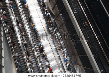 Motion blur of crowd Asian people transport on escalator at subway underground station in Hong Kong. Public transportation, Asia city life, or commuter urban lifestyle. Top high angle view, copy space