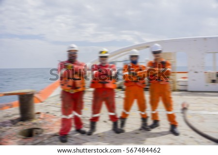 Motion blur effect. Deck crew standing together at stern vessel after finished anchor handling activities.
