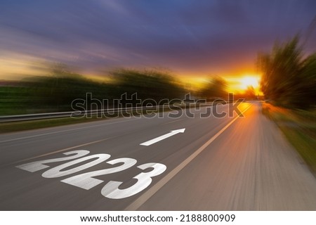 Motion blur empty asphalt road and New year 2023 concept. Driving on an empty road to Goals 2023 with sunset.