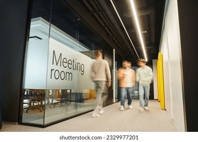 motion blur of energetic and ambitious business people walking near meeting room in coworking environment of modern office with high tech interior, full length, dynamic business concept - Shutterstock ID 2329977201