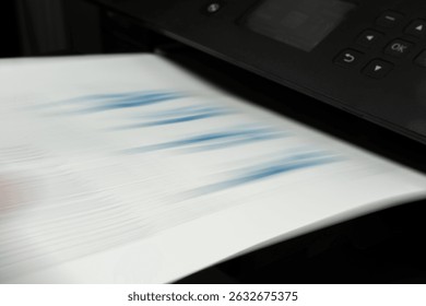 Motion blur of high-speed printer ejecting financial report page with blue chart, concept of productivity and automation