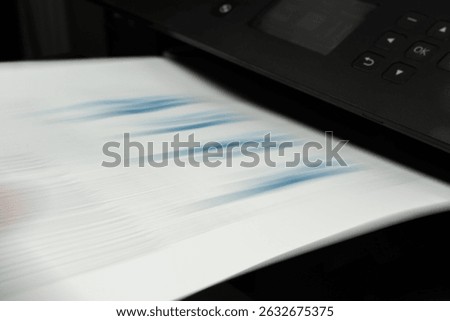 Motion blur of high-speed printer ejecting financial report page with blue chart, concept of productivity and automation
